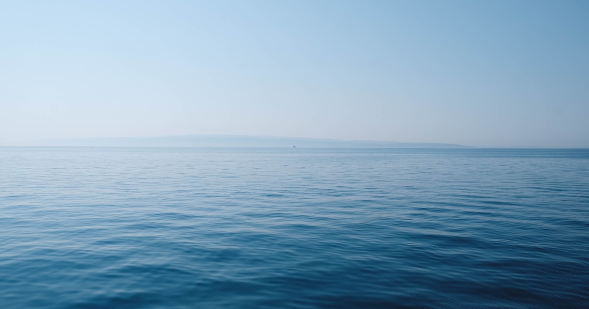 穏やかな水平線が広がる海の風景。辞めるか続けるかの判断を落ち着いて考えるイメージ