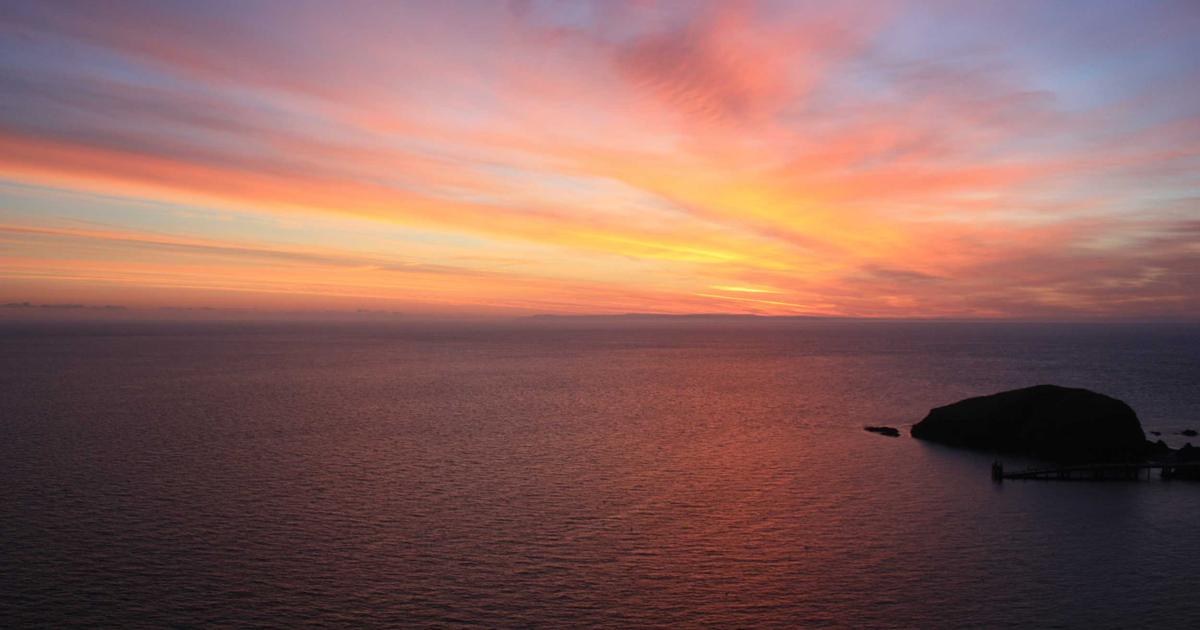 夕暮れの海と小さな島の風景。区切りをつけるイメージ