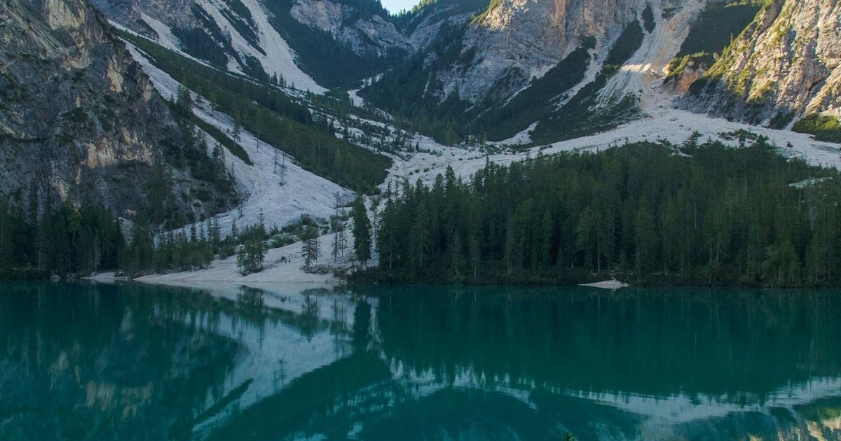 木立と山並みに囲まれた湖の風景