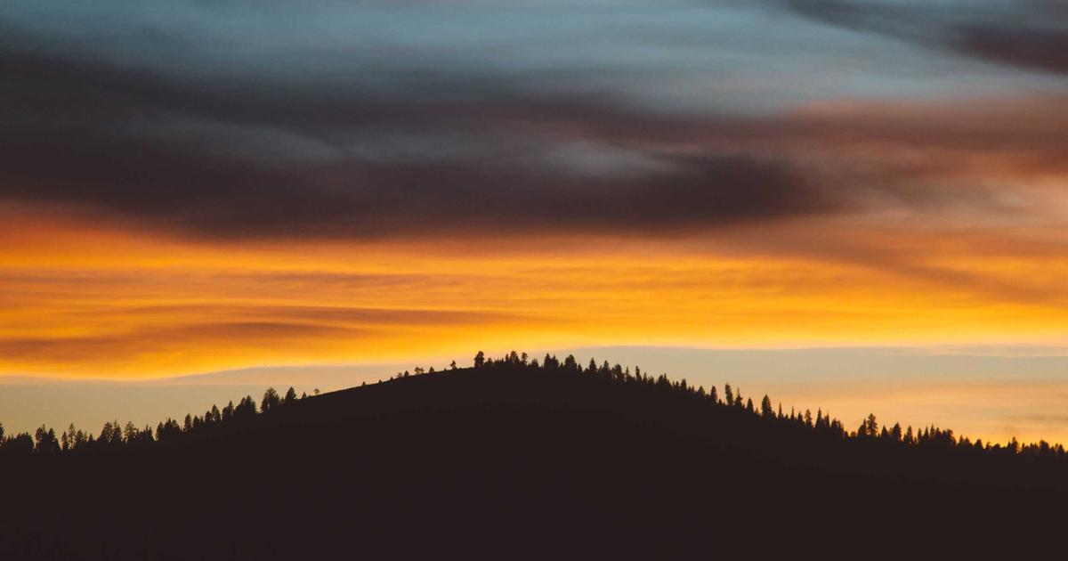 夕暮れの山の稜線。静かに沈む空が、落ち着いた気質を思わせるイメージ